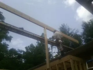 Carpenter setting a ridge beam over a new addition frame — Ice Dam Removal by Roofing Brothers in San Marino