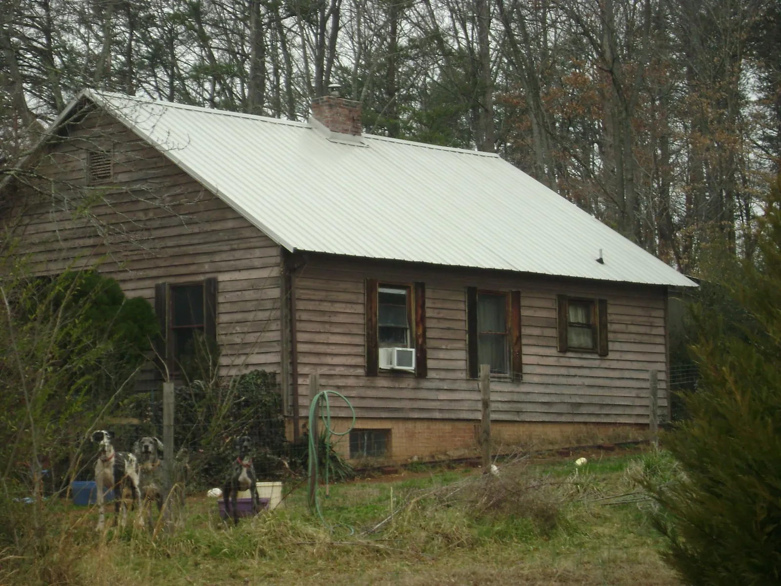 White metal roof on an old wood sided farmhouse, from a Metal Roof Installation job in San Marino